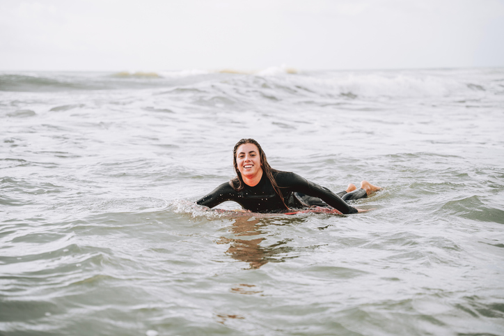 Portrait of a female surfer in the sea looking at the camera
