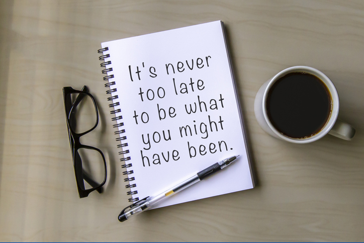 Notepad and inspirational quote It's never too late to be what you might have been.