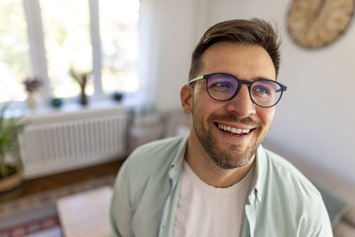 Smiling Man With Glasses Inside Brightly Lit Modern Home