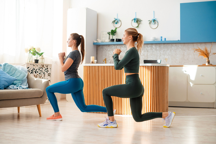 Sportswomen working out lunges during home training