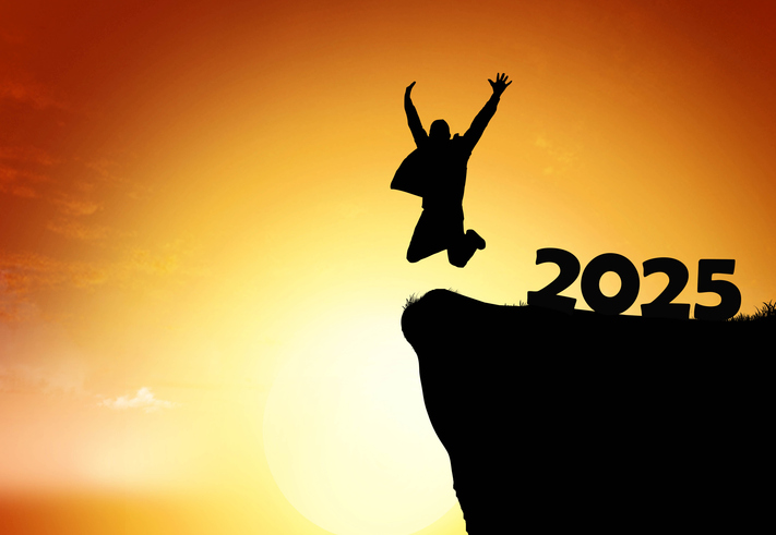 Silhouette of a person jumping joyfully at sunset while celebrating the arrival of 2025