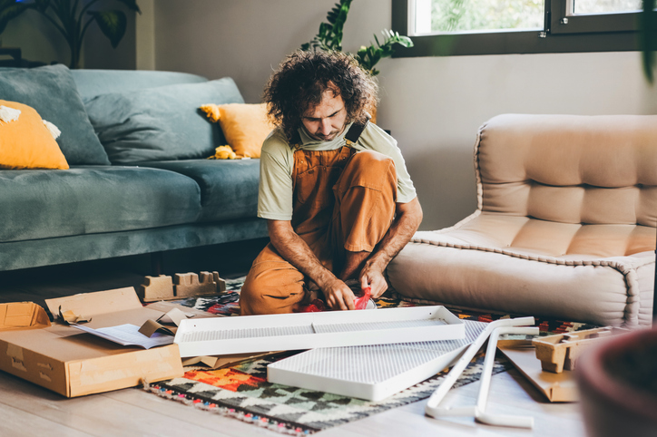 A man assembles furniture at home.