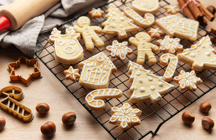 Christmas cookies cooling on rack with festive shapes and decorations,
