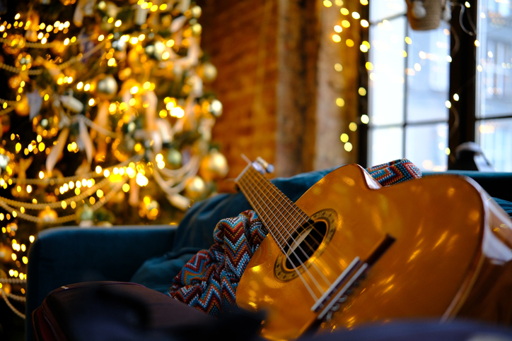 interior with decorated Christmas tree, New Year, classic guitar on sofa