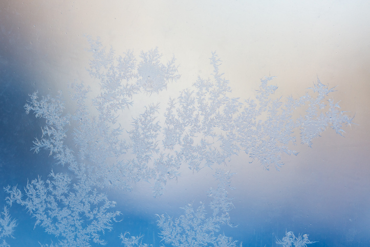 Frost patterns on window glass. Cold winter background