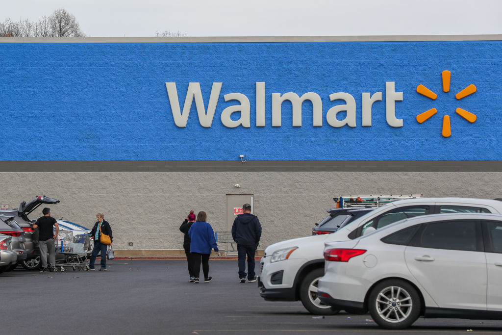 People are seen at the parking lot of a Walmart store in...