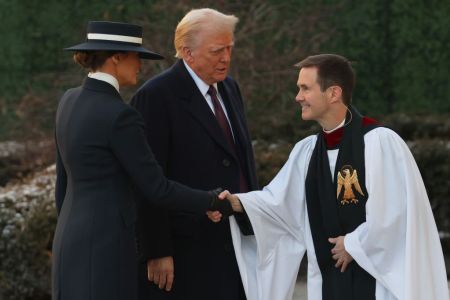 Melania Trump y el presidente electo de EE.UU. Donald Trump son saludados por el reverendo Robert W. Fisher