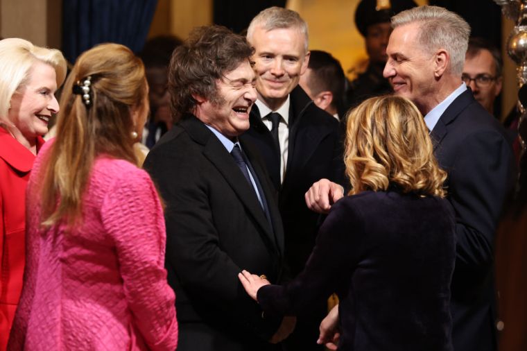 President of Argentina Javier Milei (C) speaks with former Speaker of the House Kevin McCarthy (R) as they arrive to the inauguration