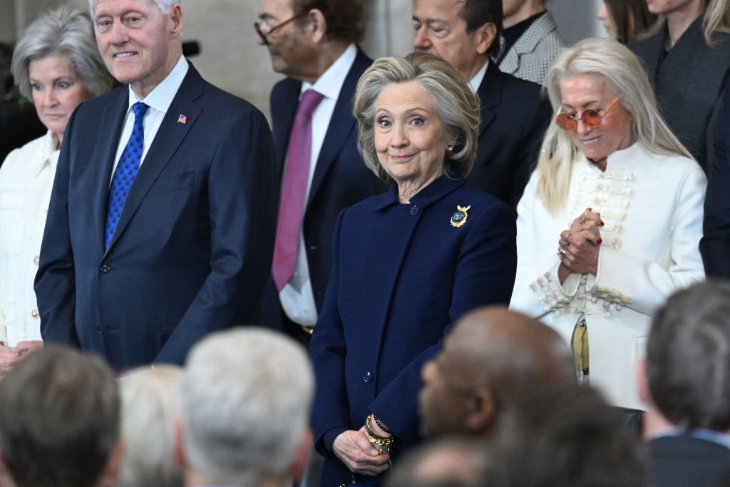 Former US Secretary of State Hillary Clinton (C) stands next to Miriam Adelson (R) as they attend the inauguration