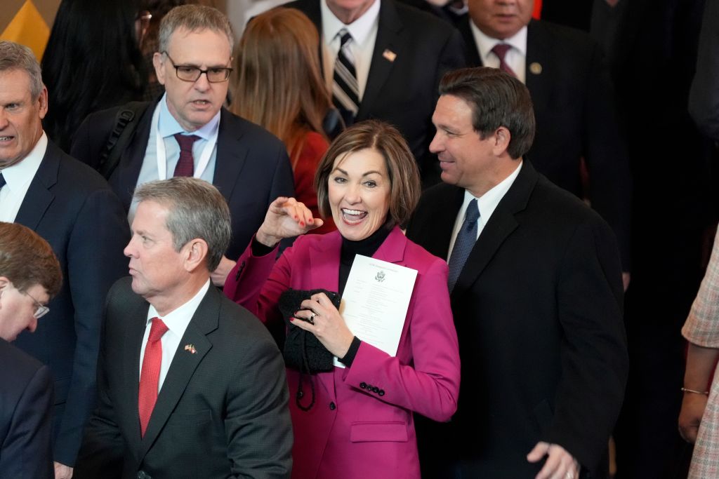 Iowa Gov. Kim Reynolds (C) and Florida Gov. Ron DeSantis (R) arrive in the VIP viewing area in Emancipation Hall for the Inauguration