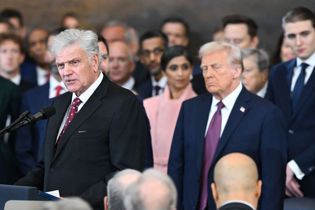 US President-elect Donald Trump (C) looks on as evangelist president of Samaritan's Purse Franklin Graham (L) devliers an invocation.