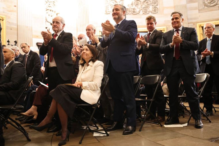 Ted Cruz (R-TX) and other guests react as US President Donald Trump gives a speech during inauguration