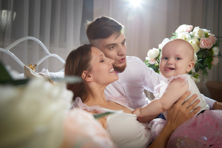 A family shares a joyful moment with their baby girl playing with a