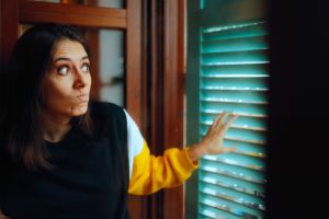 Curious Woman Spying on her Neighbors Looking Through a Window