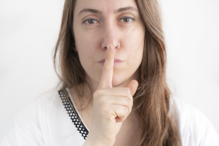 Woman with finger on her lips.