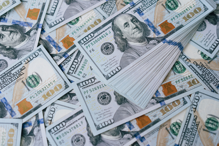 Scattered Hundred Dollar Bills Depicting United States Currency and Wealth