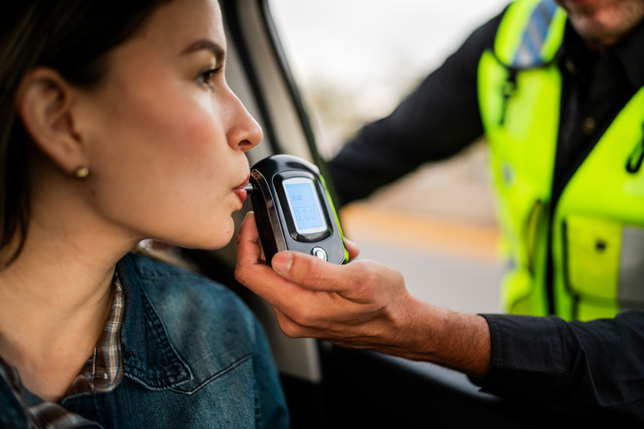 Young woman doing driver alcohol test on street