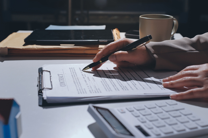 Female Real Estate Broker presenting and advised to model home and building project detail in the office, sign purchase sales contract, agreements concerned mortgage loan offer and insurance.