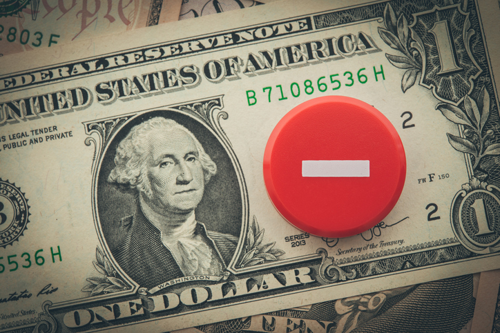 Minus symbol on US dollar banknotes background.