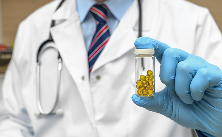 Doctor holding medicine in hand, close-up