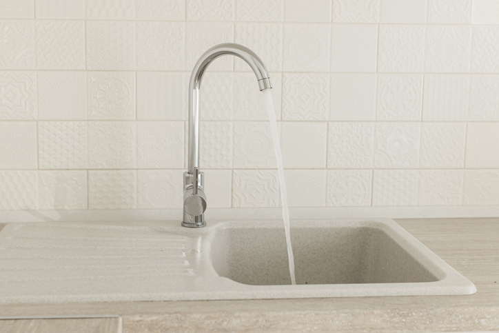 Water flowing from faucet in kitchen