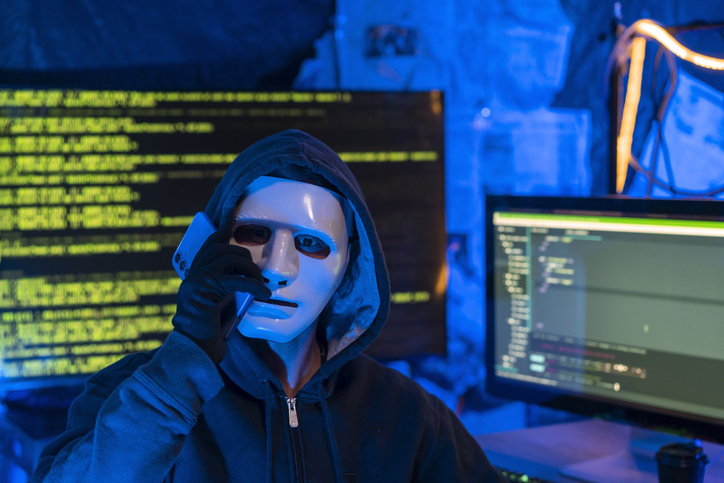 Hooded hacker doing computer sabotage
