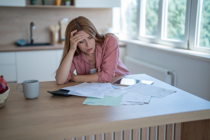 Stressed young woman managing home finances and calculating bills