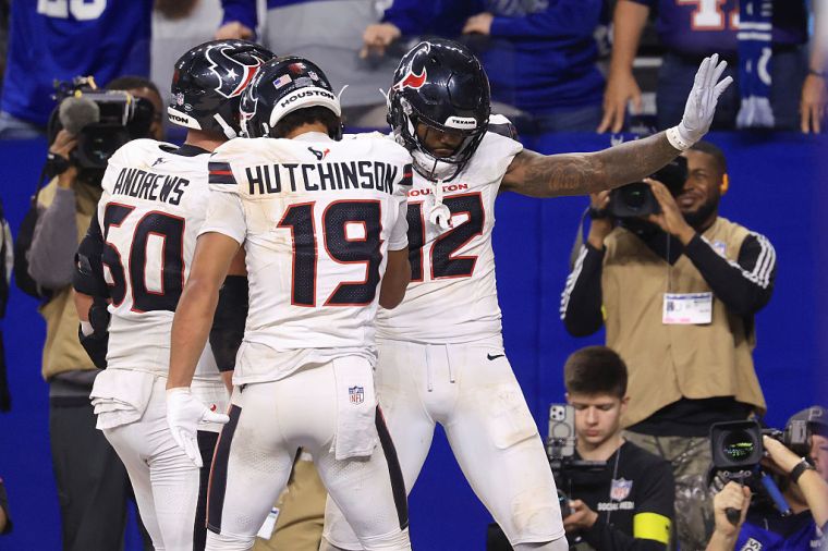 Nico Collins #12 of the Houston Texans celebrates with Xavier Hutchinson #19 and Jake Andrews #60 after his rushing touchdown