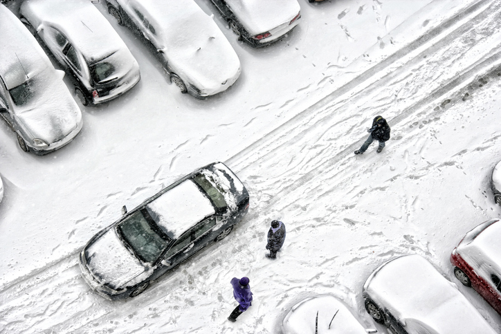 Aerial view of group of people walking on snow covered city street