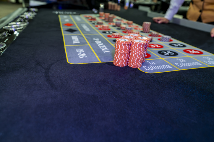 Stacks of roulette chips on casino betting table representing gambling, risk, strategy, finance, luck, entertainment and gaming atmosphere