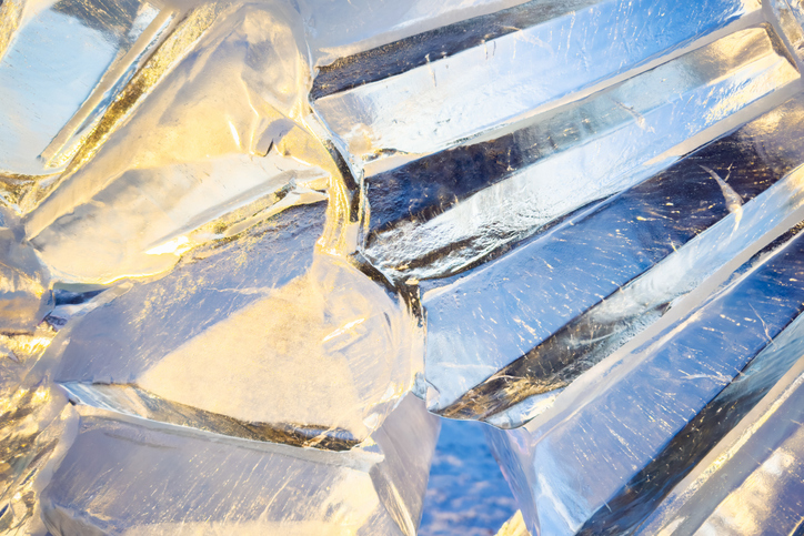 An exquisite ice sculpture beautifully reflects the sunlight, creating a stunning display at a winter festival in a snowy outdoor setting