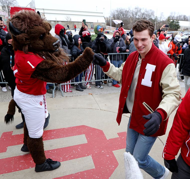 Indiana Hoosiers quarterback Fernando Mendoza high fives the IU mascot as he enters Memorial Stadium for the team celebration