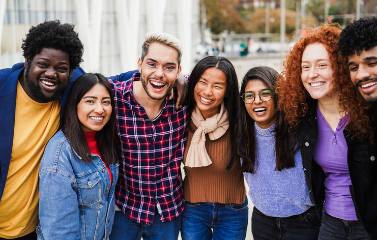 Young multiracial people having fun outdoor laughing together - Diversity and lifestyle concept during fall season - Main focus on center man face