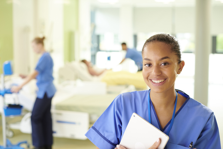 female nurse using digital tablet on ward