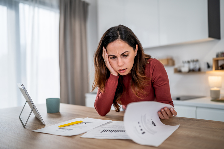 Woman feeling frustrated checking home finance documents