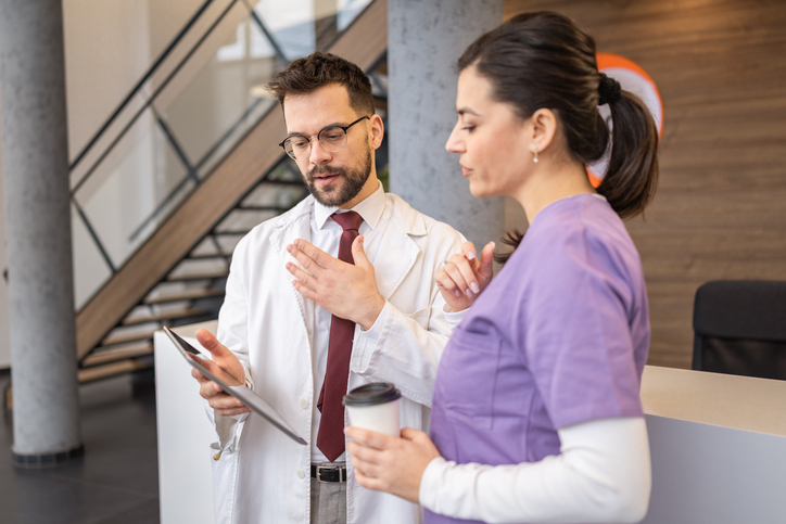 Healthcare professionals discussing medical data using digital tablet