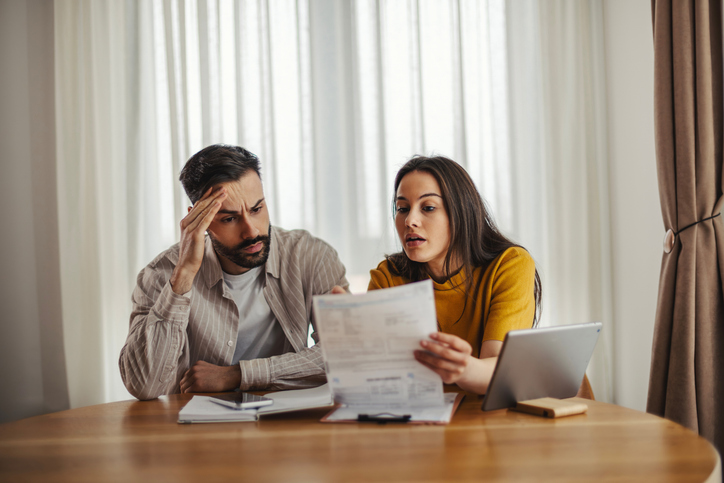 Stressed young couple managing finances and growing debt