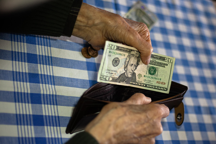An empty wallet or with very little money in the hands of an old man.