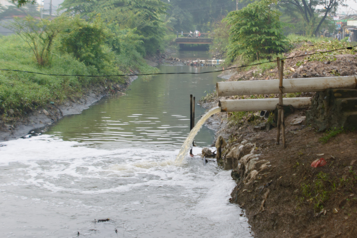 Waste water discharge pipe into river water flow
