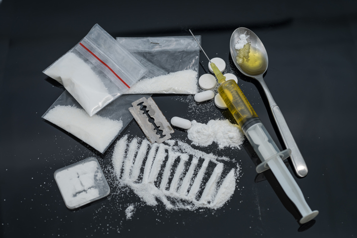 Drug syringe and cooked heroin on spoon