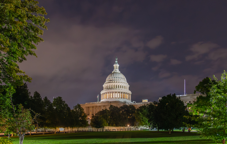 Famous United States Capitol Building under a cloudy sky at night