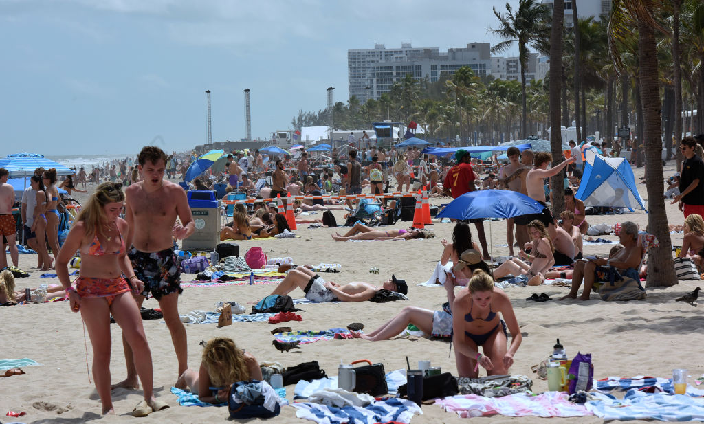 People gather at the beach as college students and others