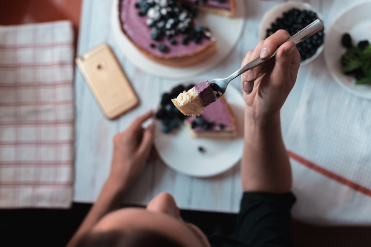 Top view holding cheesecake bite on fork