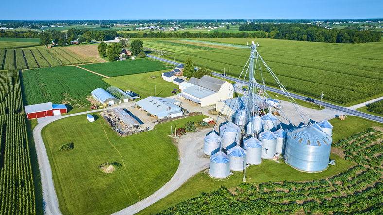 Aerial View of Grain Silos and Farm Buildings in Lush Countryside