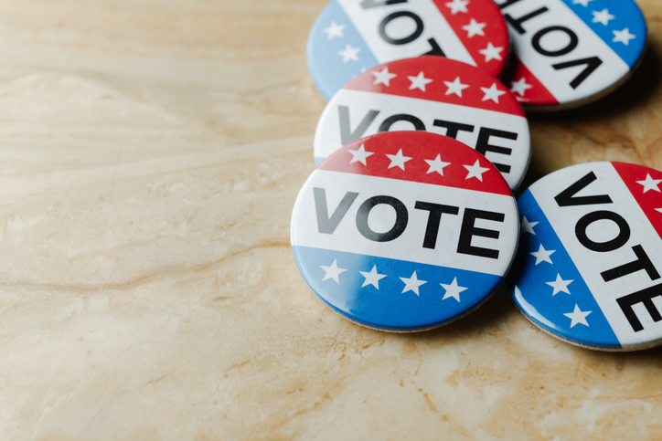 several vote badges scattered on a table