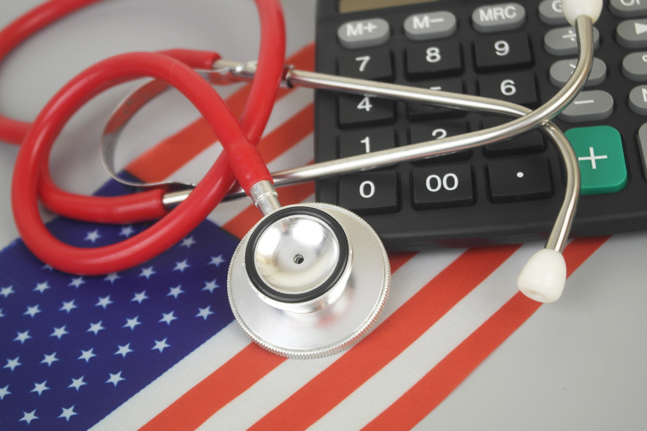 Red stethoscope and calculator on flag of USA.