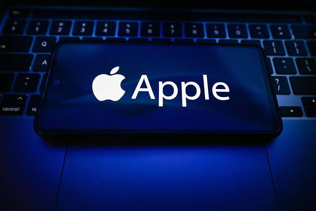 In this photo illustration, an Apple logo is seen displayed