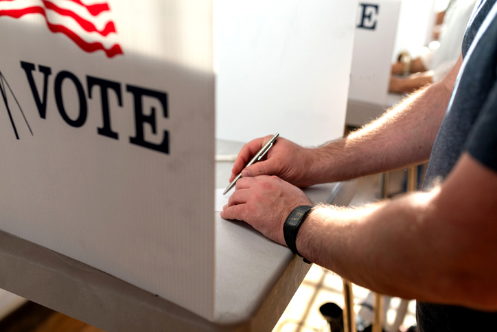 Person voting in election booth.