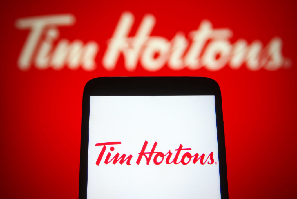 In this photo illustration a Tim Hortons logo of a