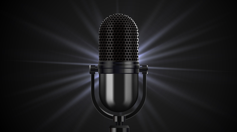 Elegant vintage microphone with glowing light rays on a dark background.
